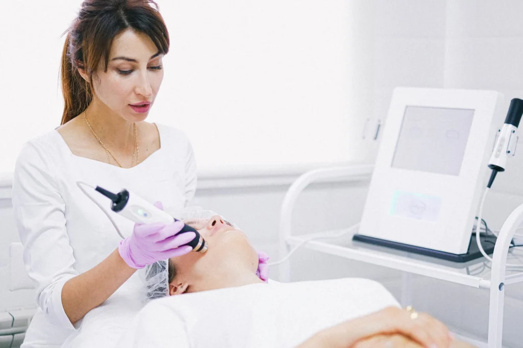 Profissional está aplicando ultrassom no rosto de uma paciente